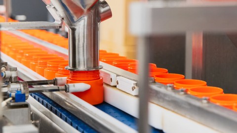 Container being filled with marijuana and sealed with cap